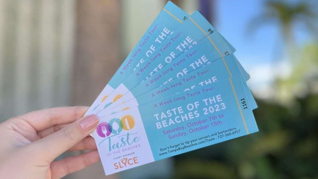 a hand holding tickets for the taste of the beaches 2023.