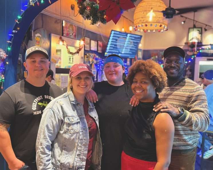 five people standing and smiling at the camera — they all work at Gulfport Brewery, Gulfportian of the Year for The Gabber Newspaper