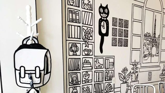 Interior shot of backpacks, tables and shelving, all black and white