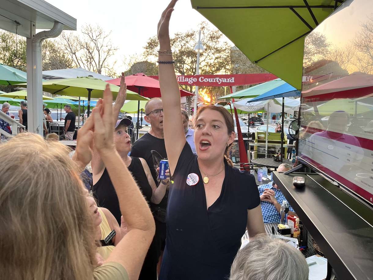 a woman cheering with her arm in the air.