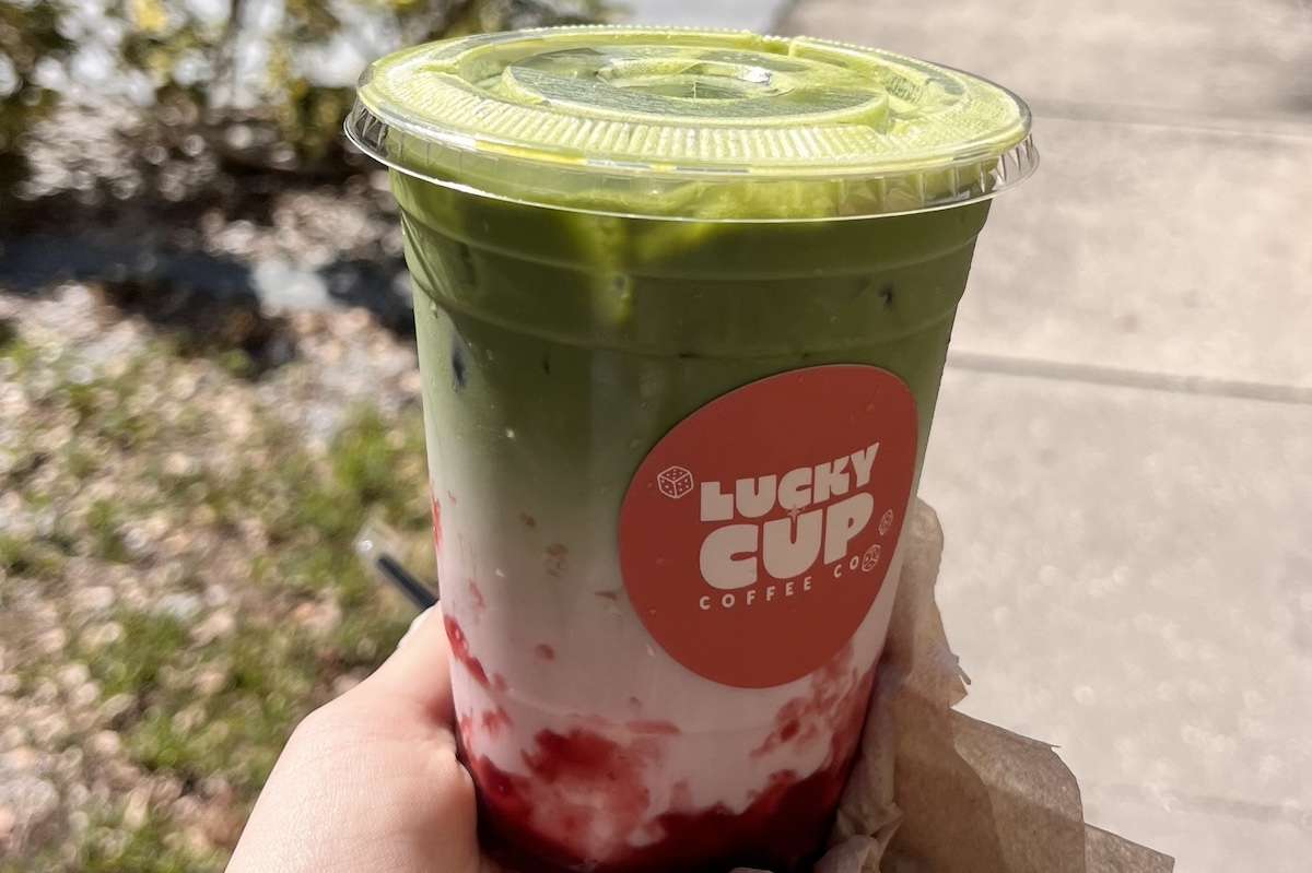 a green and pink drink with a sticker that reads "Lucky Cup"