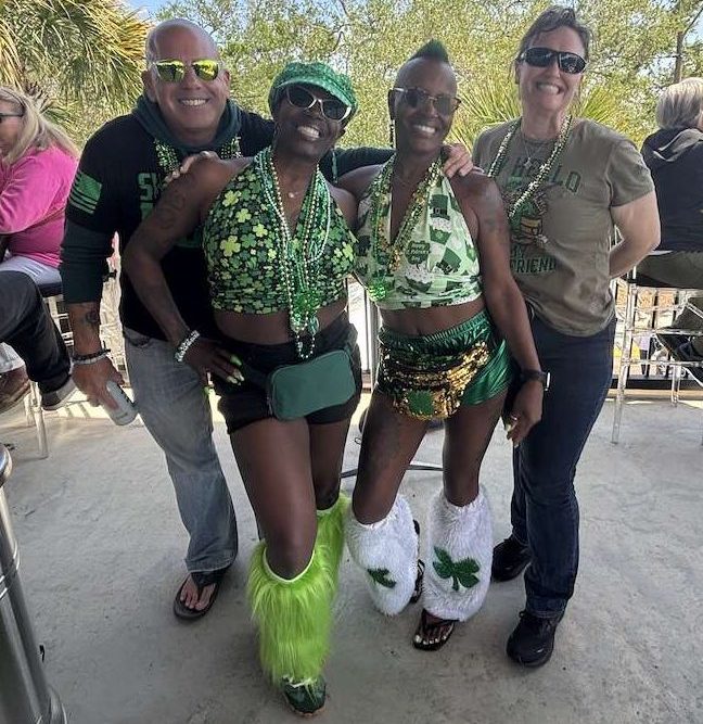 Three women and a man dressed up for St. Patrick's Day.