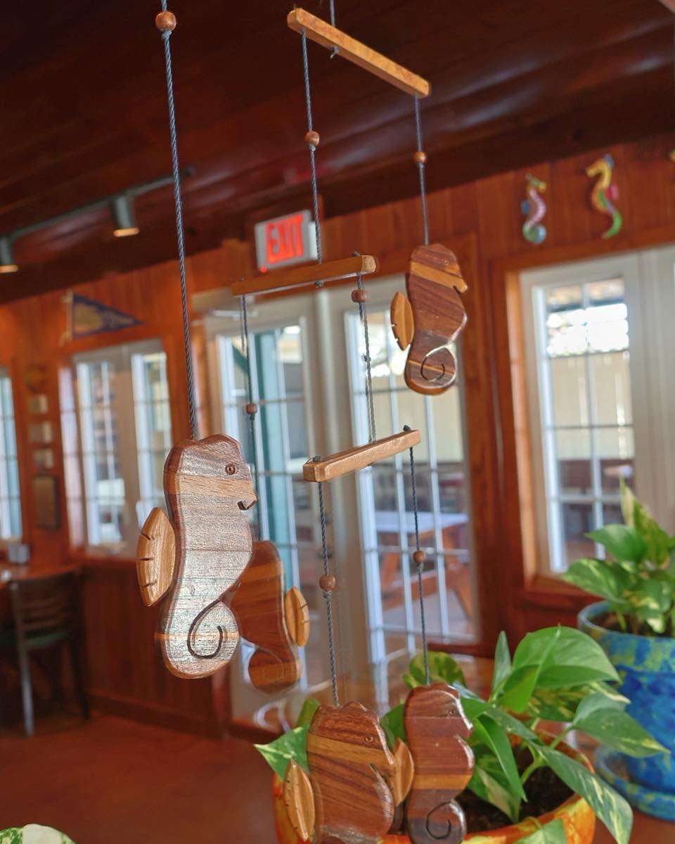 Wooden seahorse mobile hanging indoors.