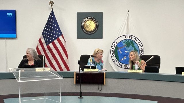Five women sitting on a dais.