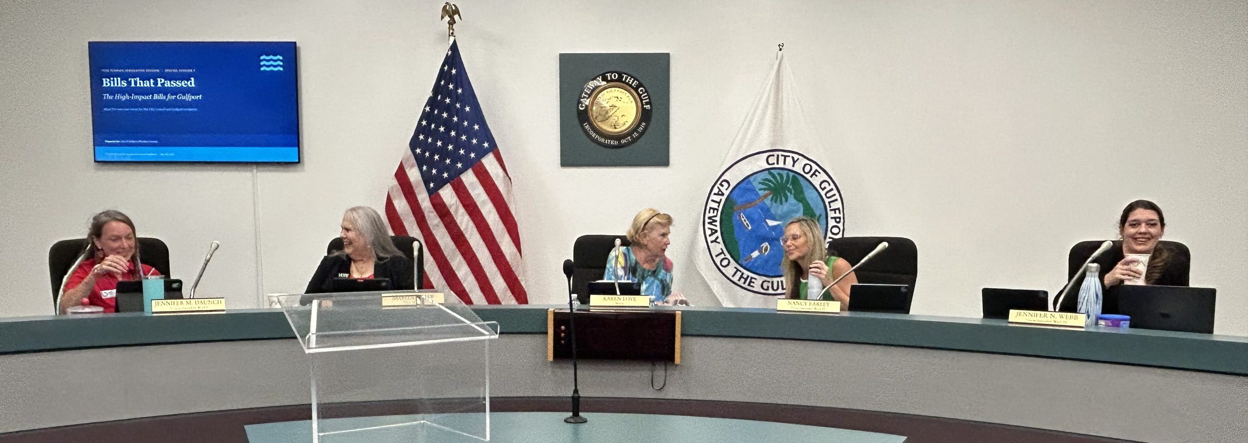 Five women sitting on a dais. 