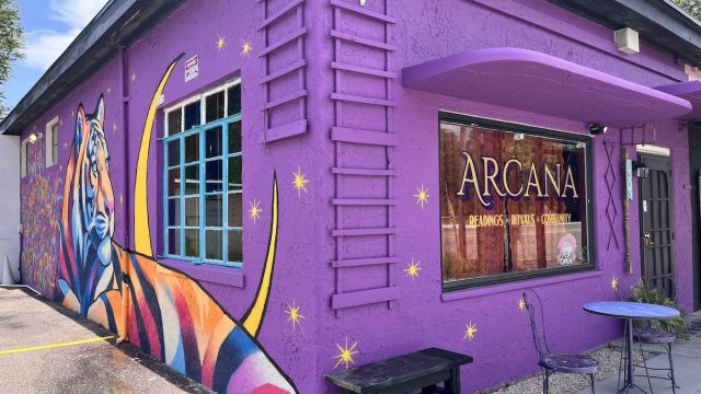 a purple building with a tiger painting and a window with words that read 