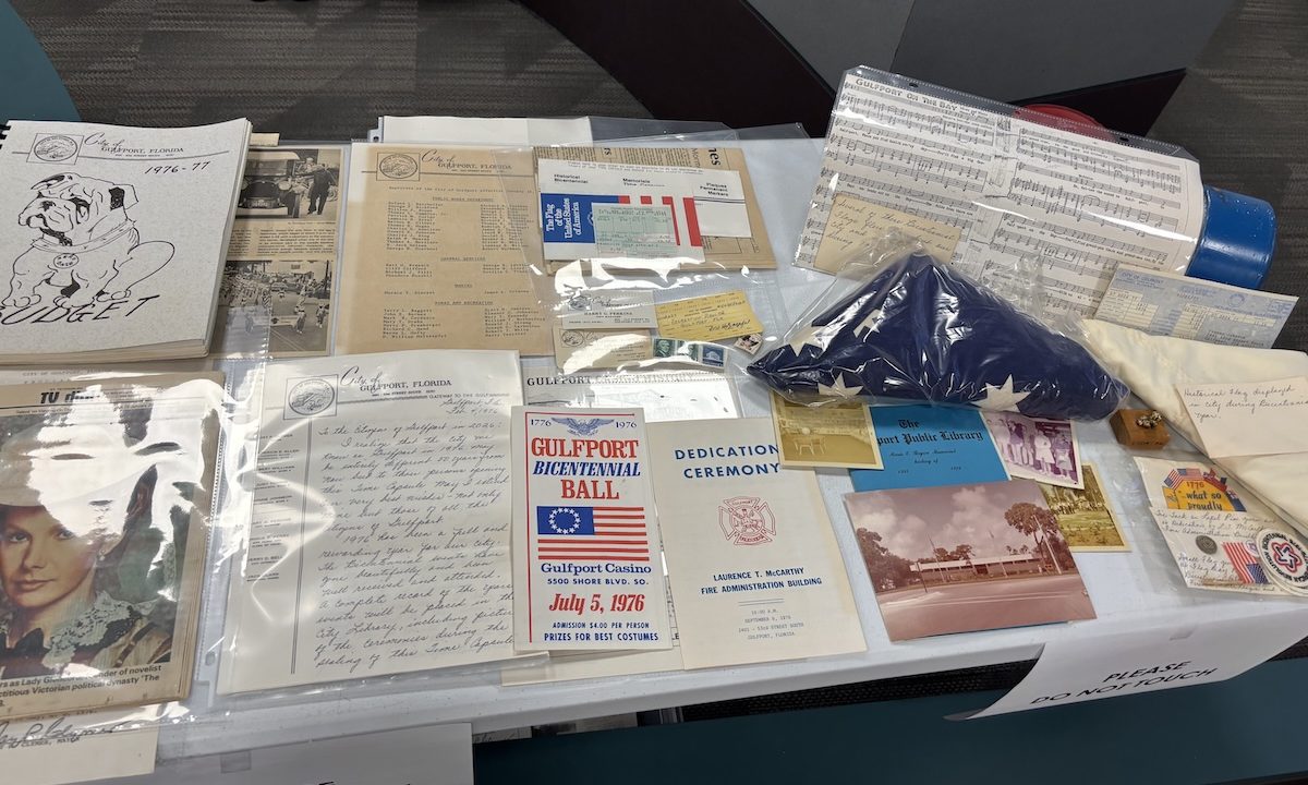 a table of items such as sheet music, a flag, pamphlets, and tickets.