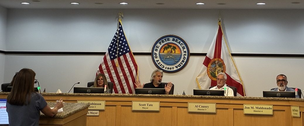 A standing woman speaks to seated commissioners