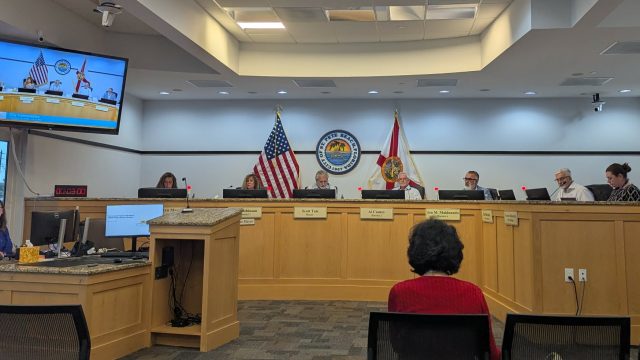 people sitting on a dais with about two people sitting in front of it.